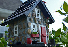 Cute birdhouse with red door white windows and a blue roof, funny birdfeeders, cute birdhouse picture.