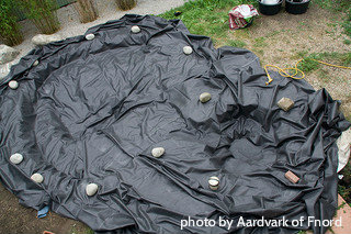 Large pond with flexible liner laid out with rocks holding it down, flexible pond liners, installing a pond.