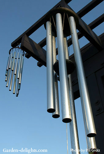 One large tube wind chimes with matching small tube aluminum wind chimes hung from a wooden pergola, deep bass wind chimes, metal/metallic wind chimes.