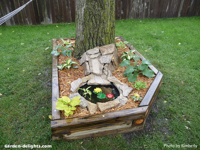  Mini pond built around a large tree with landscape ties filled with dirt and woodchips with surrounding shale rocks around the small pond area with green plants planted around the border of the landscape ties, small water gardens, small bowl ponds, pond containers ideas, many pond garden, DIY Mini pond, unique water ponds for backyard, garden watered decor, Zen outdoor water features, outdoor living, great way to add life and natural features to your garden is with your own backyard small water feature.