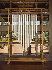 Long metal tube windchimes mounted to bamboo frame in courtyard, musical when tribes, bamboo wind chimes.