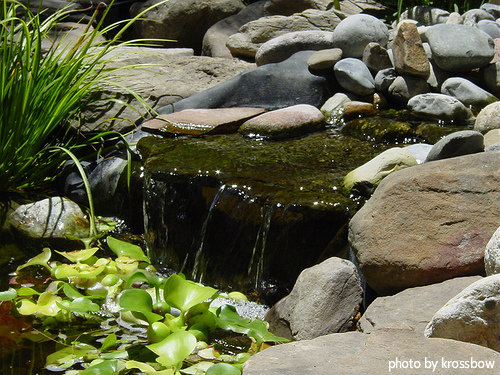 Small garden water feature with water stream surrounded by rocks pouring into lower pond, find proper pump size, backyard water features.