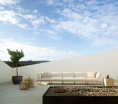 Cleaning Outdoor Furniture,White sectional with big cushions two pillows and two end tables with tree in big flower pot.