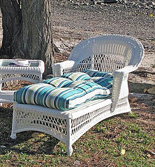 Martha Stewart Outdoor Furniture, White Wicker chase chair and an table with blue stripe cushion.