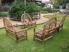 Rustic Outdoor Furniture, two chairs and loveseat country style wooden chairs on grass.
