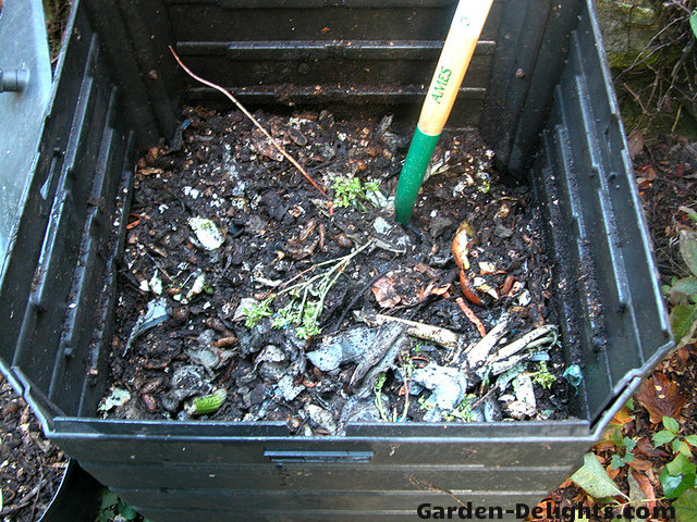 Soil and organic material inside of compost bin with pitchfork,composting tools, compost turner, gardening forks, aerated compost bin, compost stirrer.in