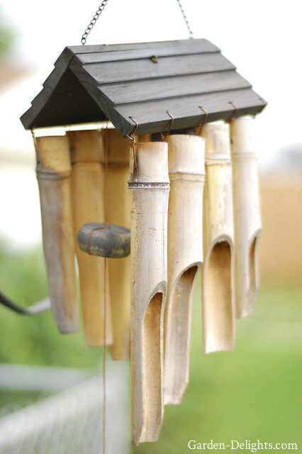 Small roof with hanging wooden bamboo reeds with wooden striker. Natural bamboo chimes, wood windchimes.